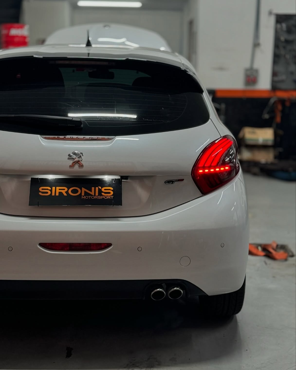 Peugeot 208 GT branco na oficina da SIRONI´S MOTORSPORT com placa personalizada